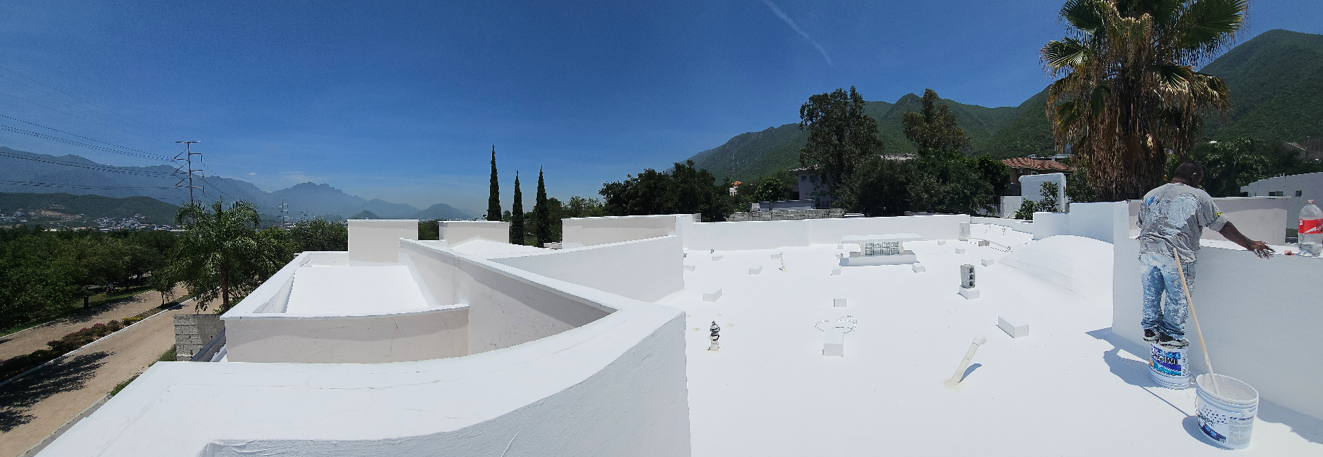 Aplicación de impermeabilizante acrílico blanco en azotea residencial